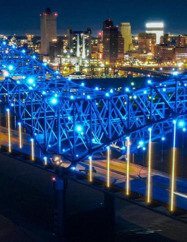 Dark night sky against blue lit Memphis bride with city skyline in the background