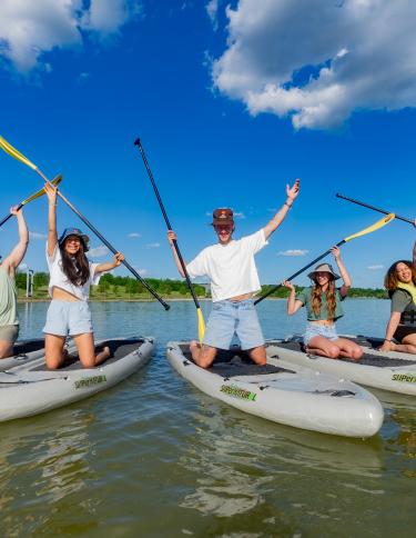 a group of paddle boarders post for photo at Shelby Farms Park