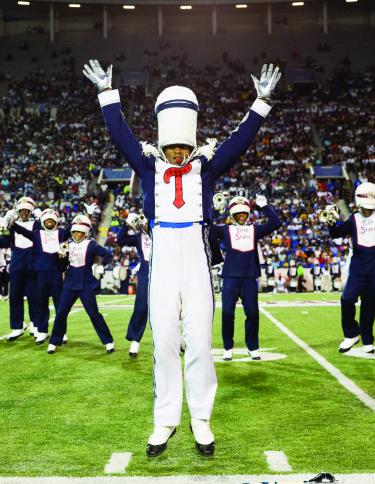 Band director leading band on football field