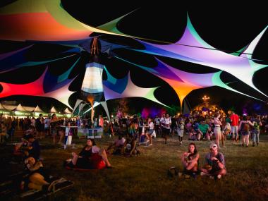 Guests relax around the grounds of Mempho Music Festival. Multicolored tents provide shade.