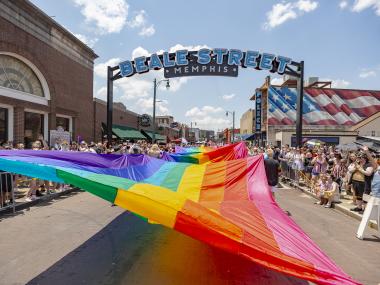 massive pride flag being held up during pride parade on beale street