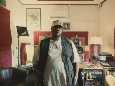 African American Man standing in front of recording equipment with his hands in pockets