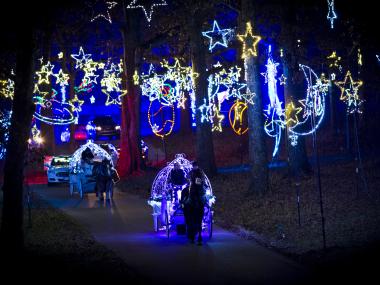 Horse-drawn carriages riding through annual holiday lights attraction Starry Nights at Shelby Farms Park.