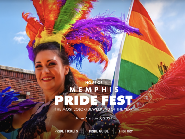a woman with rainbow feathers in her hair red and blue feathers on her body marching in the parade