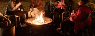 people sitting around a fire at night at park