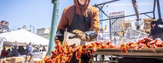 man pushes crawfish into bucket