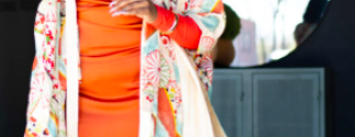 african american woman in a bright orange dress wearing sunglasses