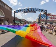 massive pride flag being held up during pride parade on beale street