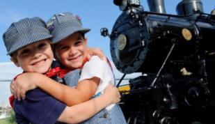 Two young boys dressed as train conductors Photo