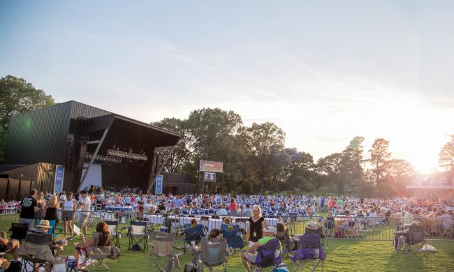crowd of people on grassy lawn at Botanic Garden with music stage