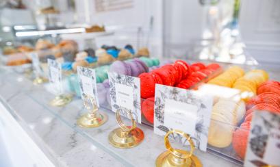 Multi-colored macaroons sit on a display shelf