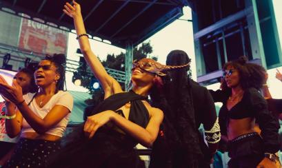 A group dancing and cheering on performers at Tone Juneteenth Gala