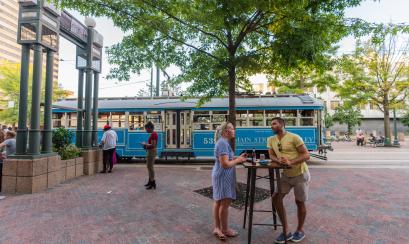 people hanging outside with blue trolley in background