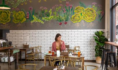 woman eats a table inside by the brewery