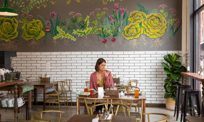 woman eats a table inside by the brewery