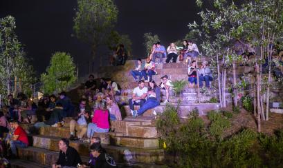 Music festival crowd sitting on stone steps at Tom Lee Park at night