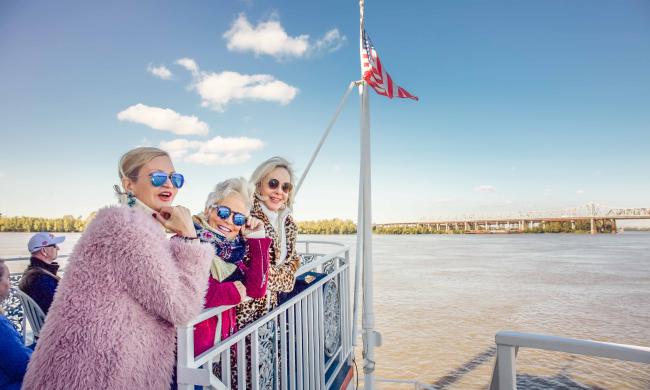 three women pose on dock of boat