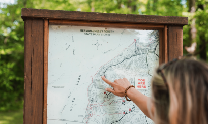 woman points at map of forest