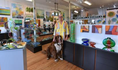 Clifton gallery owner poses in store for photo with dog