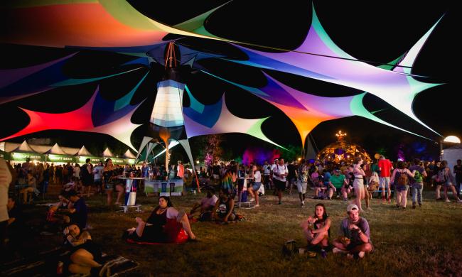 Guests relax around the grounds of Mempho Music Festival. Multicolored tents provide shade.