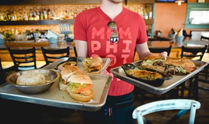server holds up plates of po boys