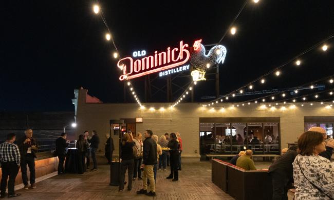 people on old Dominick rooftop with big neon sign