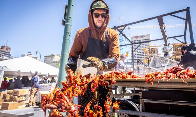 man pushes crawfish into bucket