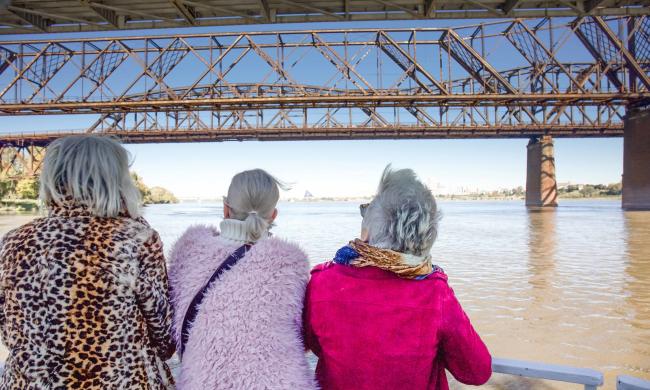 three women look at bridge from boat