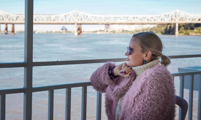 woman looks at water from boat deck