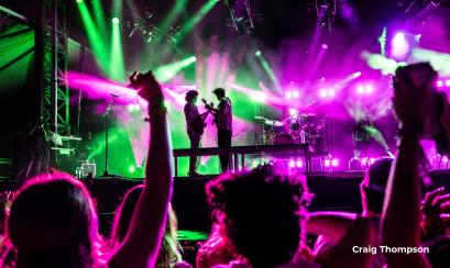 concert with bright colorful lights and cheering crowd