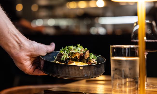the lobbyist corn mash dish being placed on a table by server