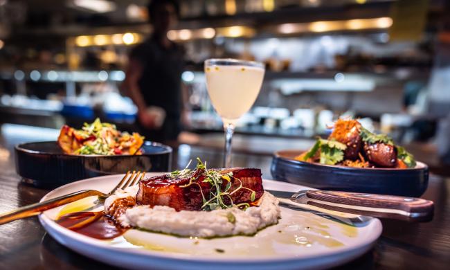 three dishes from the lobbyist on display with a drink at the bar