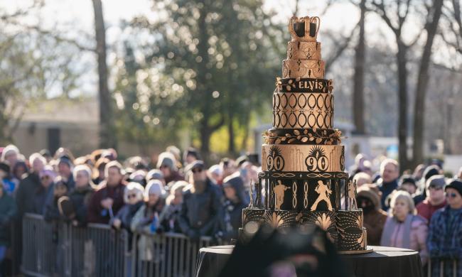 elvis 90th birthday cake on display in front of crowd at graceland lawn