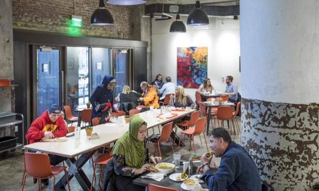 Tables full of people eating at Global Cafe inside Crosstown Concourse
