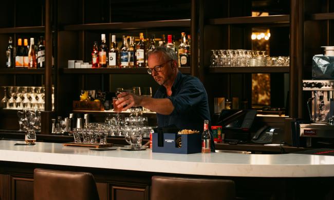 Bartender mixing drinks inside the bar and lounge The Dame at Hotel Pontotoc.