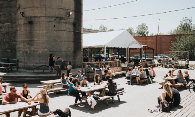 People sitting at the outdoor picnic tables at Wiseacre Brewing Co. on Broad Ave.