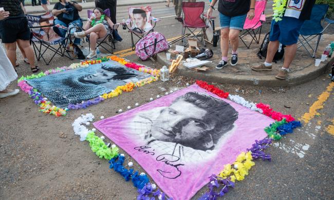 blankets with elvis face laid on ground surrounded by flowers during Elvis Week