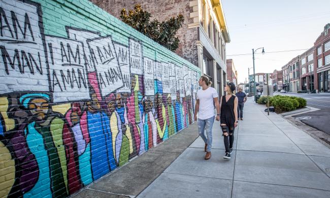 Couple walking by I Am A Man Mural on South Main Street.