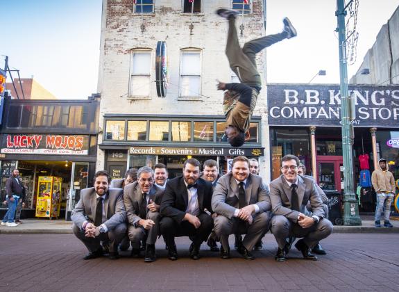 One of the Beale Street Flippers flips over a groom and groomsmen | Craig Thompson