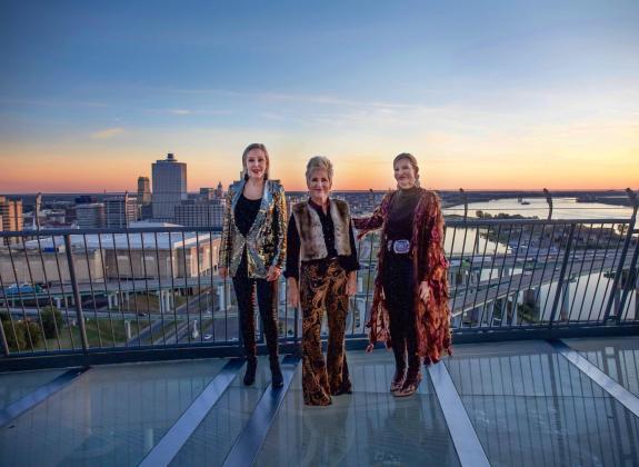 three women post on lookout of bass pro