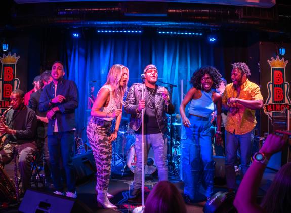 group of friends sing and dance on bb kings stage on beale