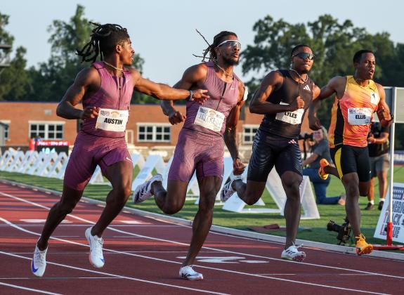 Four men running on a track