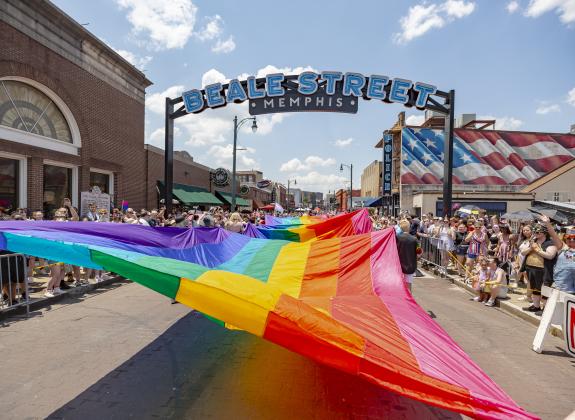 massive pride flag being held up during pride parade on beale street