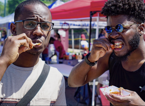 two men eating hot wings