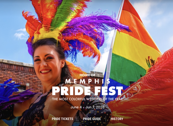 a woman with rainbow feathers in her hair red and blue feathers on her body marching in the parade