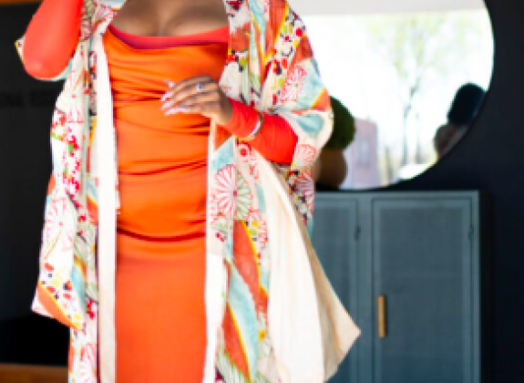 african american woman in a bright orange dress wearing sunglasses