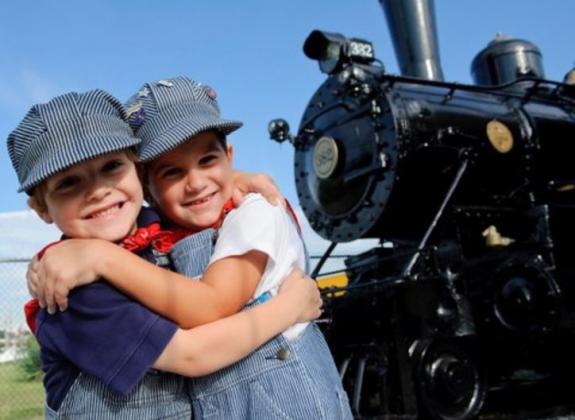 Two young boys dressed as train conductors Photo