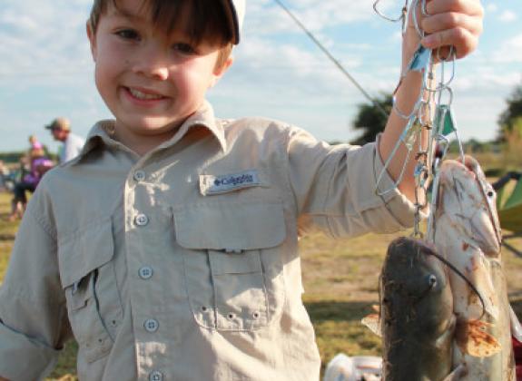 Young boy shows off his catch at the fishing rodeo at the Agricenter International Photo 2