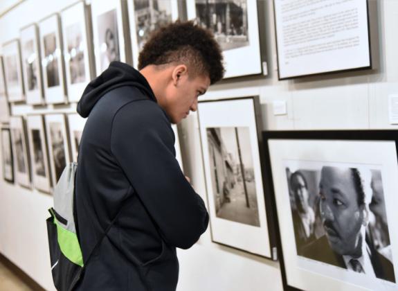 Student in the gallery look at a framed image of MLK Photo 7