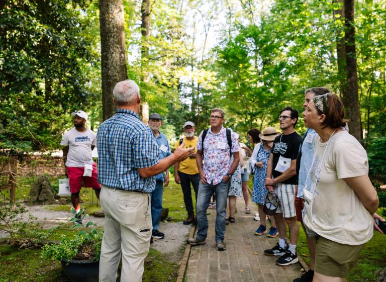 Man speaks to crowd during garden walk Photo 3